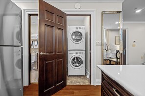 A modern kitchen with a double-door entry, stainless steel appliances, and a built-in washer and dryer. - The Sydney Boutique Inn (Charlottetown)