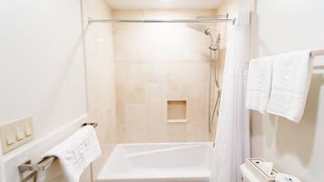 Un baño moderno con bañera, ducha e inodoro.