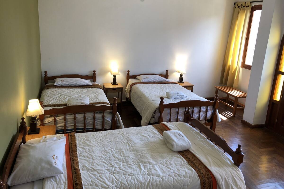 Cama individual en dormitorio mixto con baño compartido de 3 camas