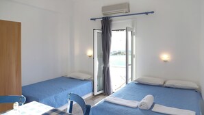 Een kamer met twee bedden, een tafel met geruit tafelkleed en een stoel.