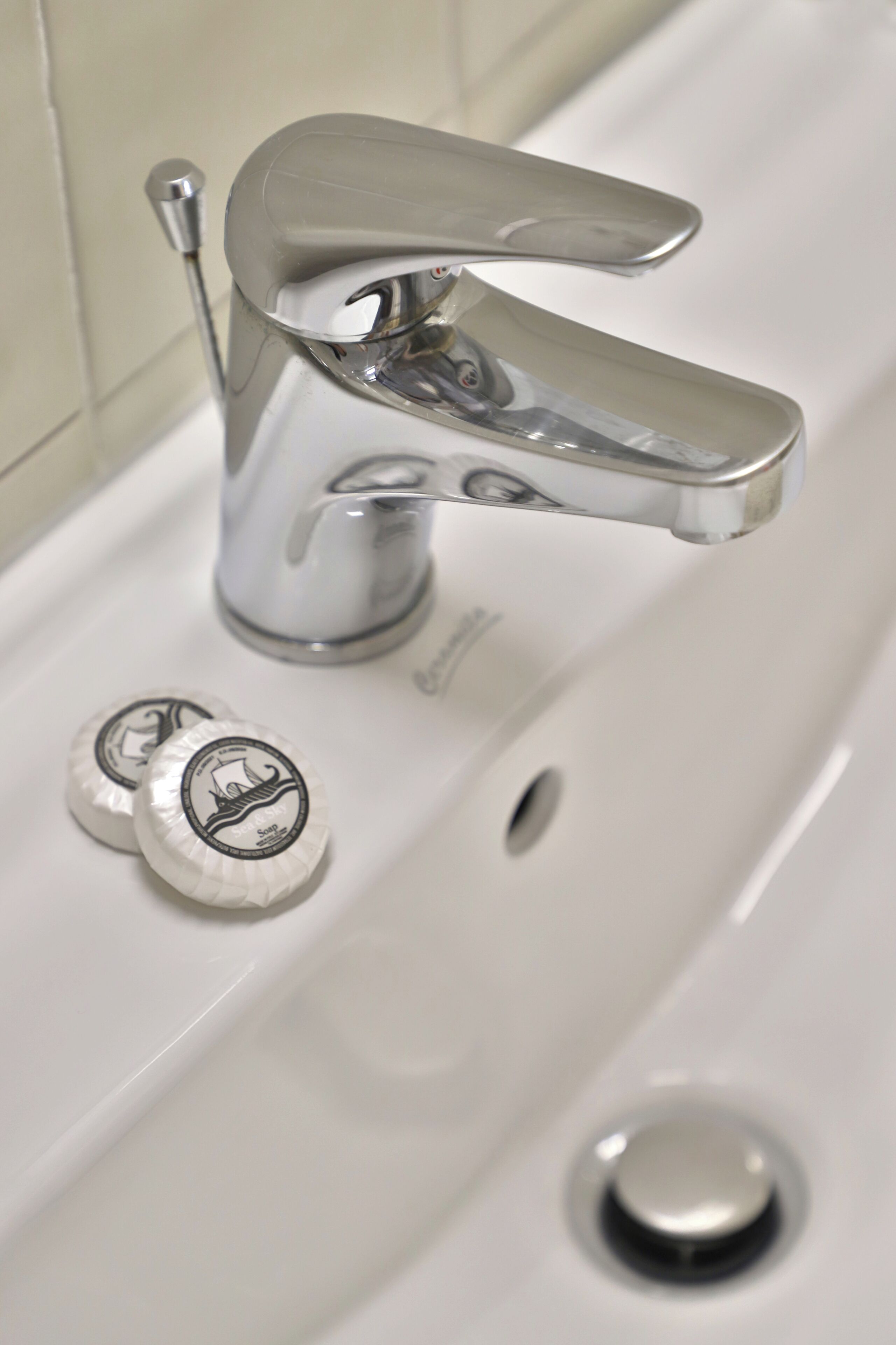 Ein Waschbecken mit einem Chrom-Wasserhahn und zwei Seifenspendern.