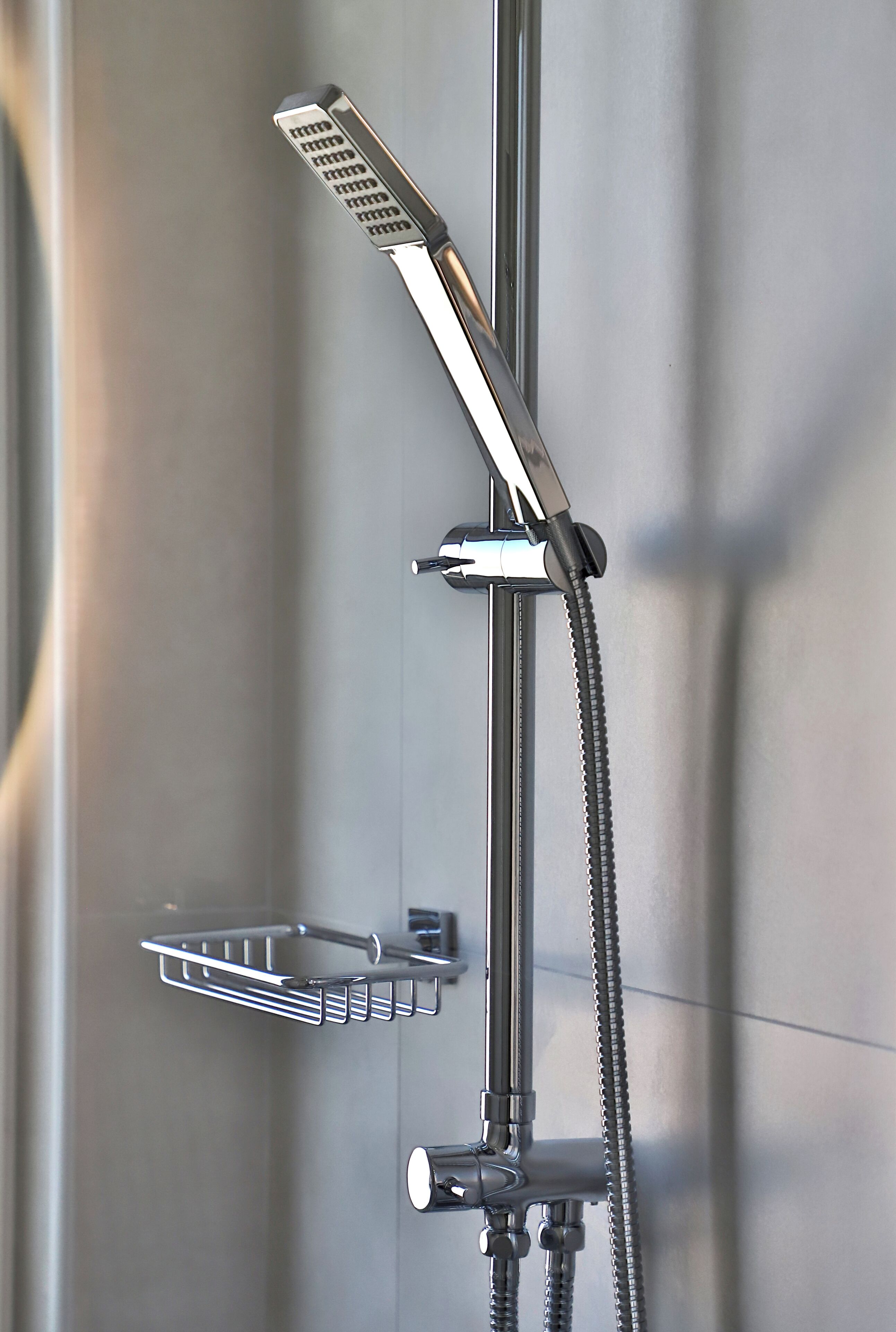 A modern shower with a handheld showerhead and a fixed wall-mounted showerhead.