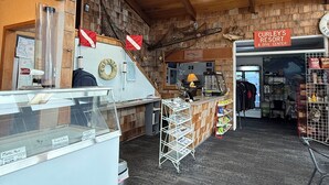 En interiör med träpanel, en receptionsdisk, en skylt för Curley's Resort & Dive Center och ett skyltfönster.