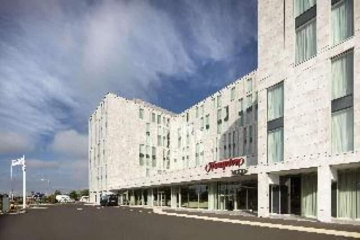Un hotel con fachada moderna, varios pisos y señalización llamativa.