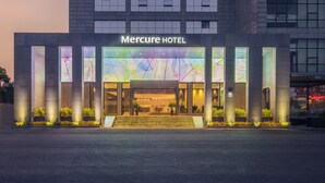 Ein modernes Hotelgebäude mit Glasfassade und beleuchteter Beschilderung.