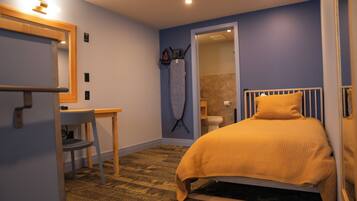 Un dormitorio con cama, escritorio y silla.