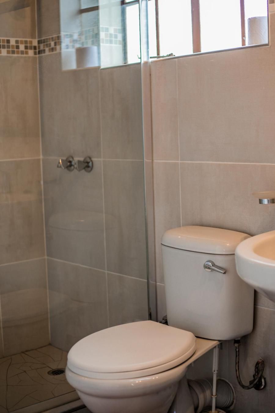 A bathroom with a toilet, sink, and shower area.