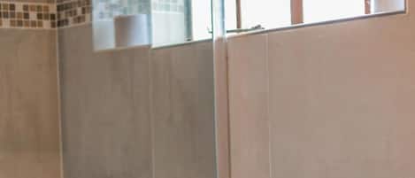 Un baño con inodoro, lavamanos y zona de ducha.