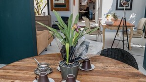 A wooden table with a potted plant, a teapot, and three cups.