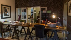 Un comedor con una mesa de madera, sillas, una lámpara y un farol decorativo.