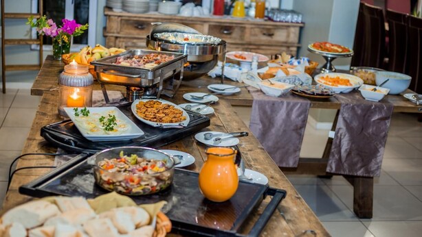 Una mesa de madera con varios platos en un bufé y una vela.