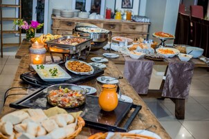 Una mesa de madera con varios platos en un bufé y una vela.