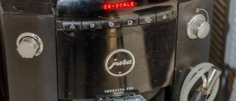 Una máquina de café con pantalla digital sirviendo café en una taza.