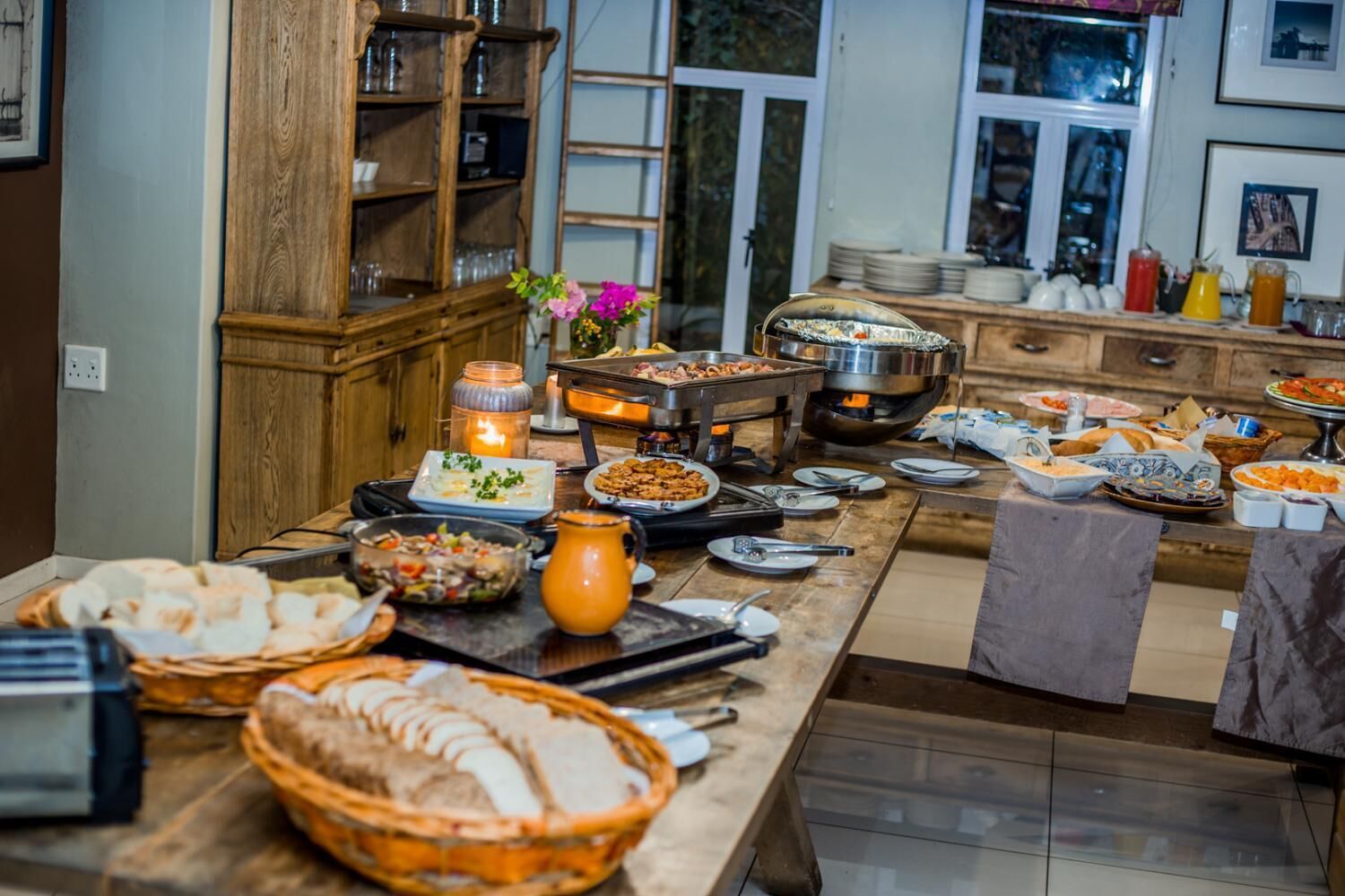 Un aparador de buffet amb diferents plats i un centre de taula amb espelmes.