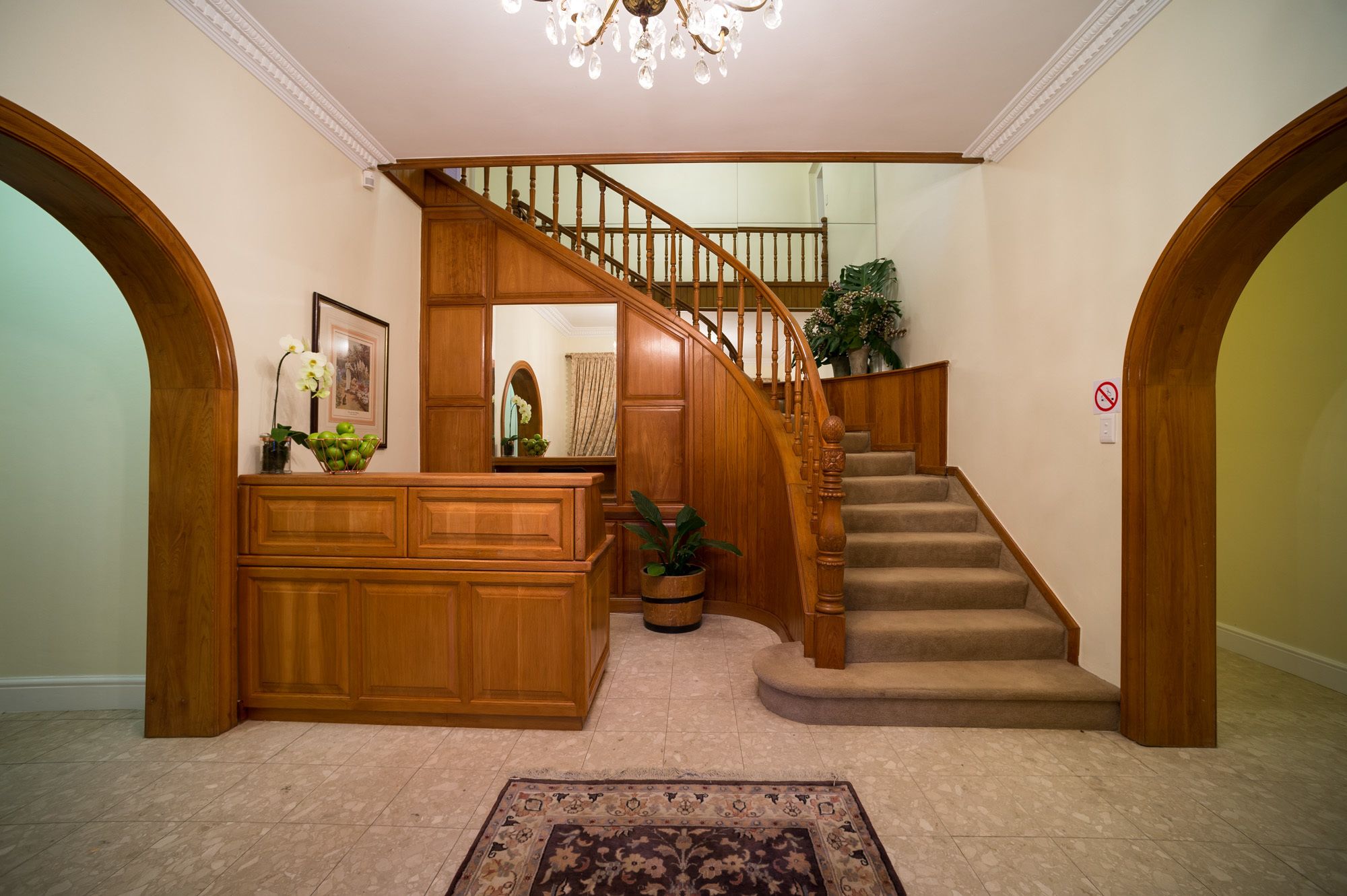 A grand staircase with wooden railings and a carpeted floor, leading to an upper level.