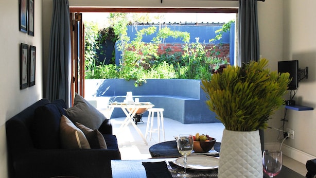 Ein Wohnzimmer mit Sofa, Couchtisch und einer Essecke mit Tisch für zwei Personen.