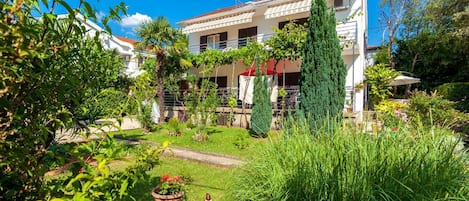 A two-story house with a garden in front.