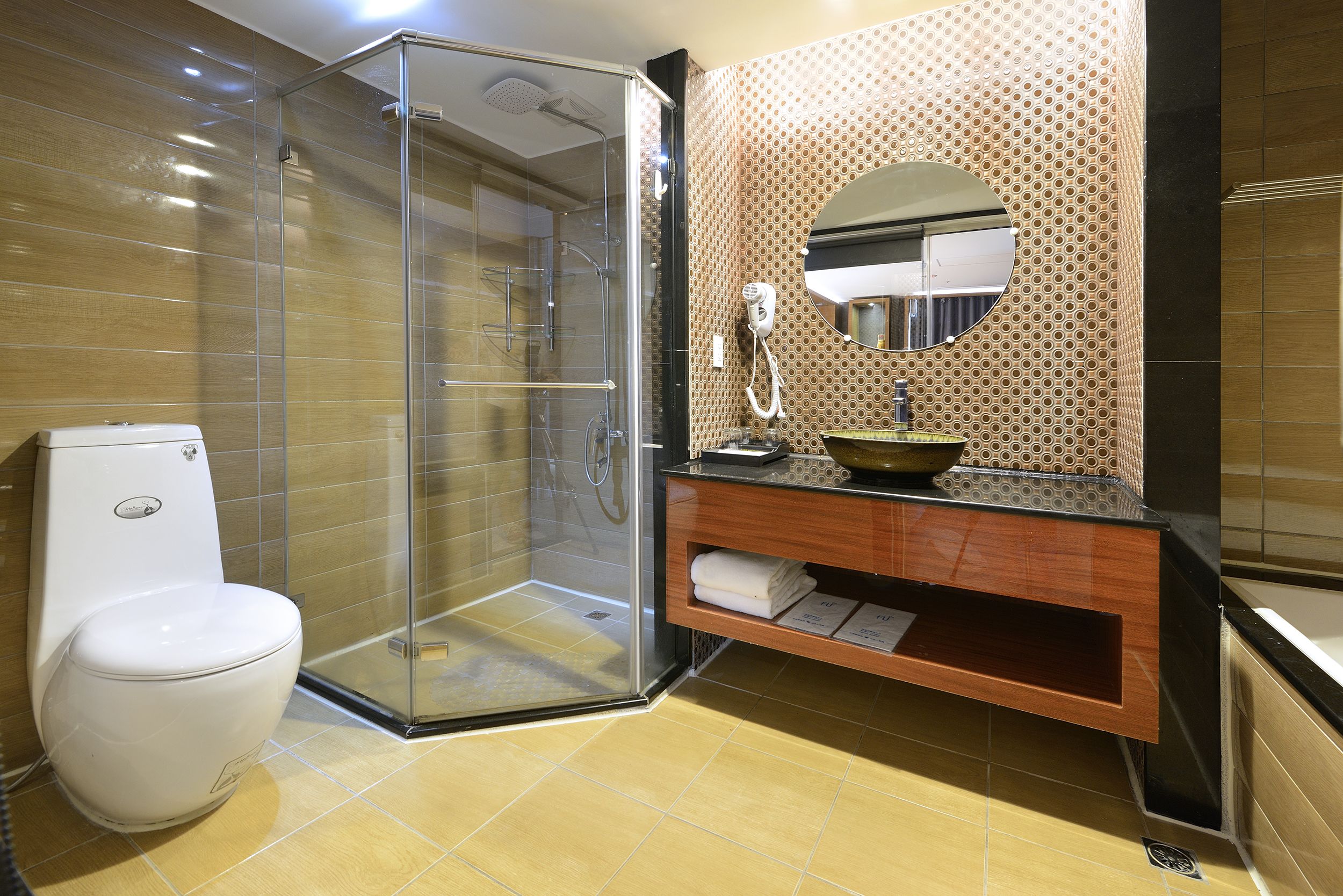 Un baño moderno con ducha envuelta en vidrio, inodoro, tocador con lavamanos y espejo.