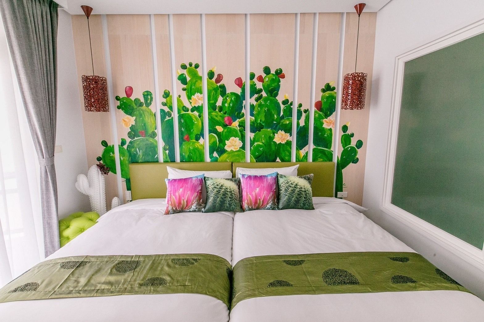 A bed with a green headboard, multiple pillows, and a green bedspread.