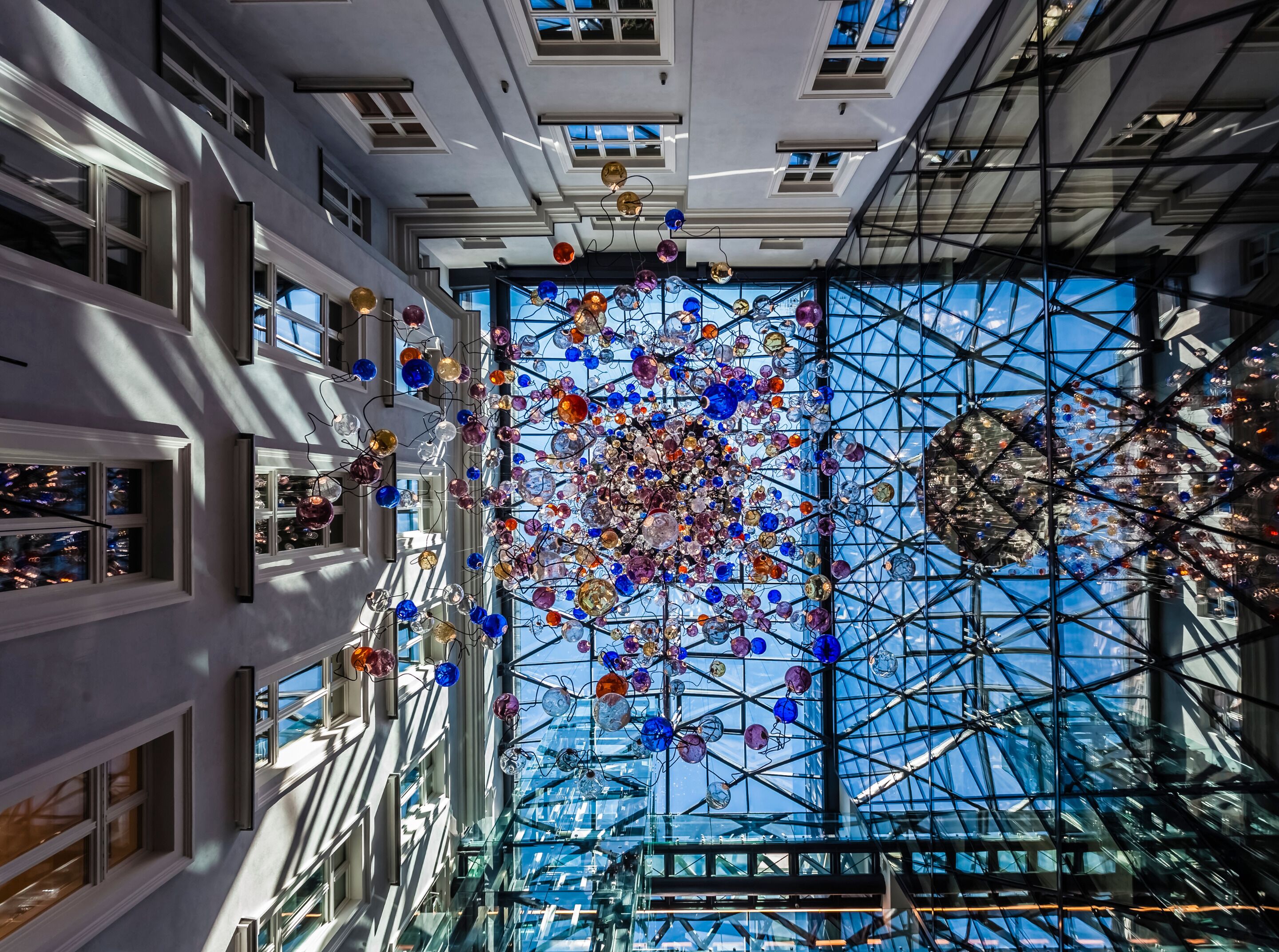 A modern building with a glass facade and a complex ceiling structure.