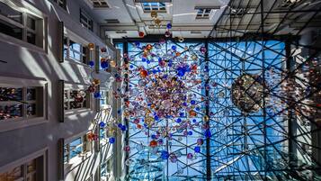 A modern building with a glass facade and a complex ceiling structure.