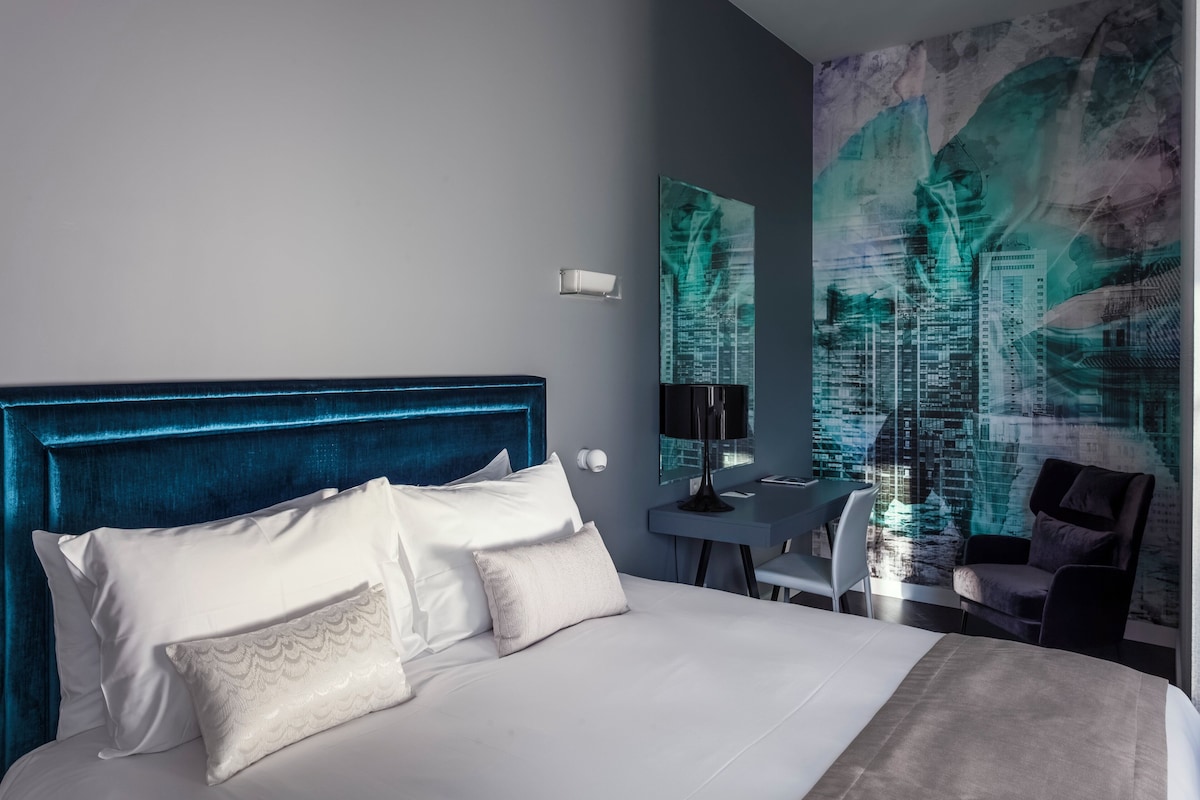 Ein Hotelzimmer mit einem großen Bett, einem Schreibtisch und einem Stuhl.