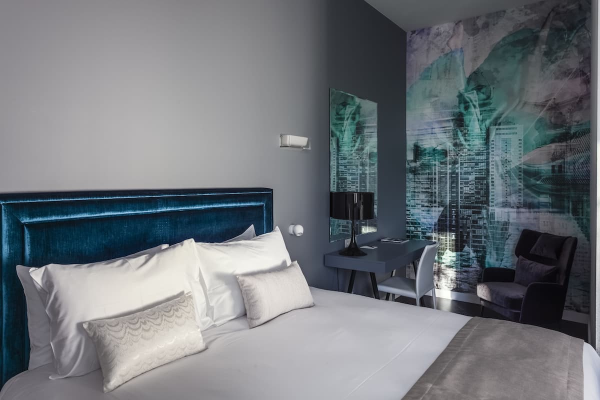 Een moderne hotelkamer met een groot bed, een bureau en een stoel.
