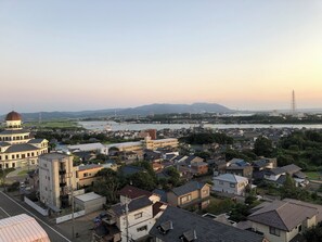 A residential area with houses, a prominent building with a dome, and a river in the background. - Mikuni Ocean Resort & Hotel (Sakai)