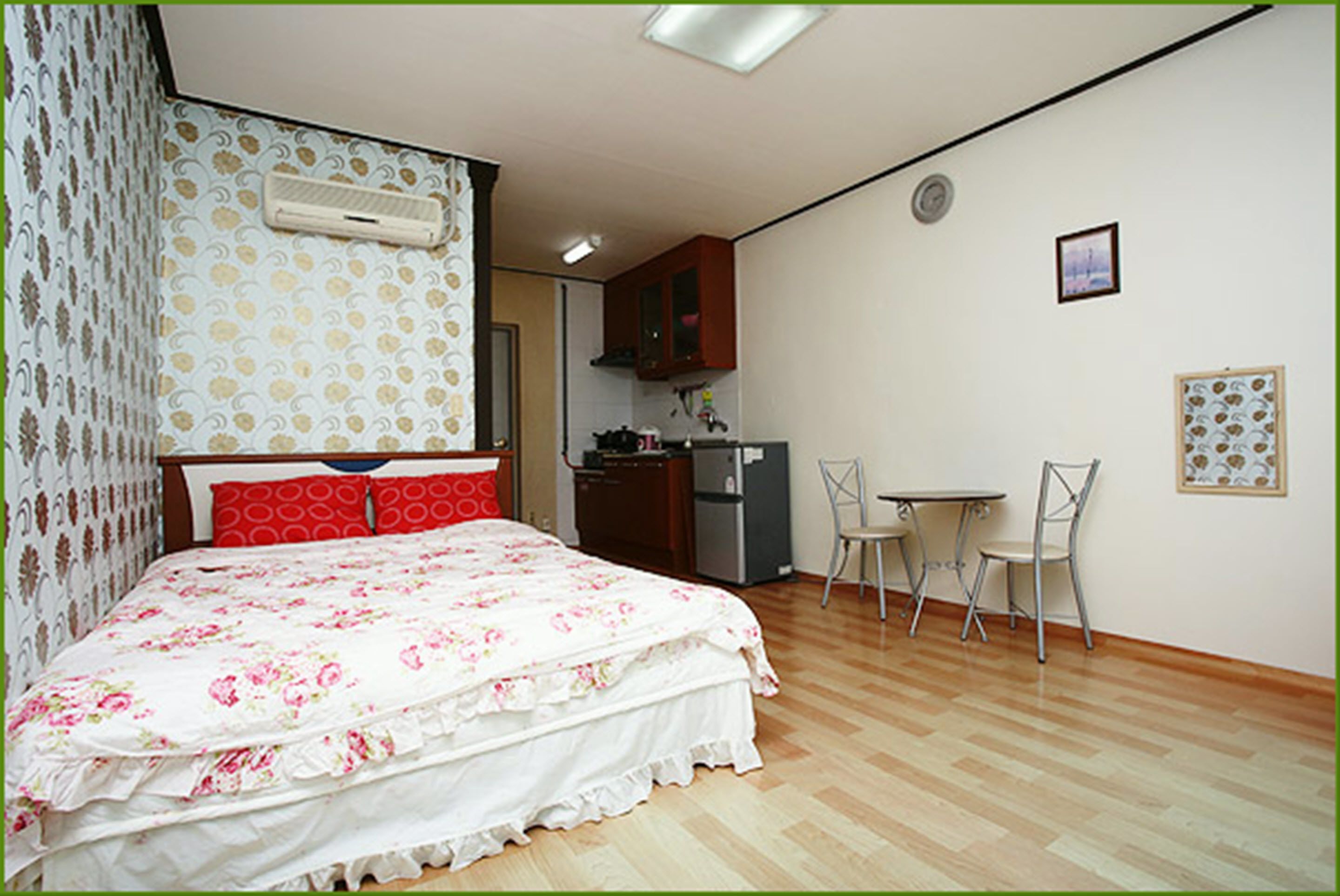 Ein Schlafzimmer mit Bett, einer kleinen Küchenzeile und einem Essbereich.