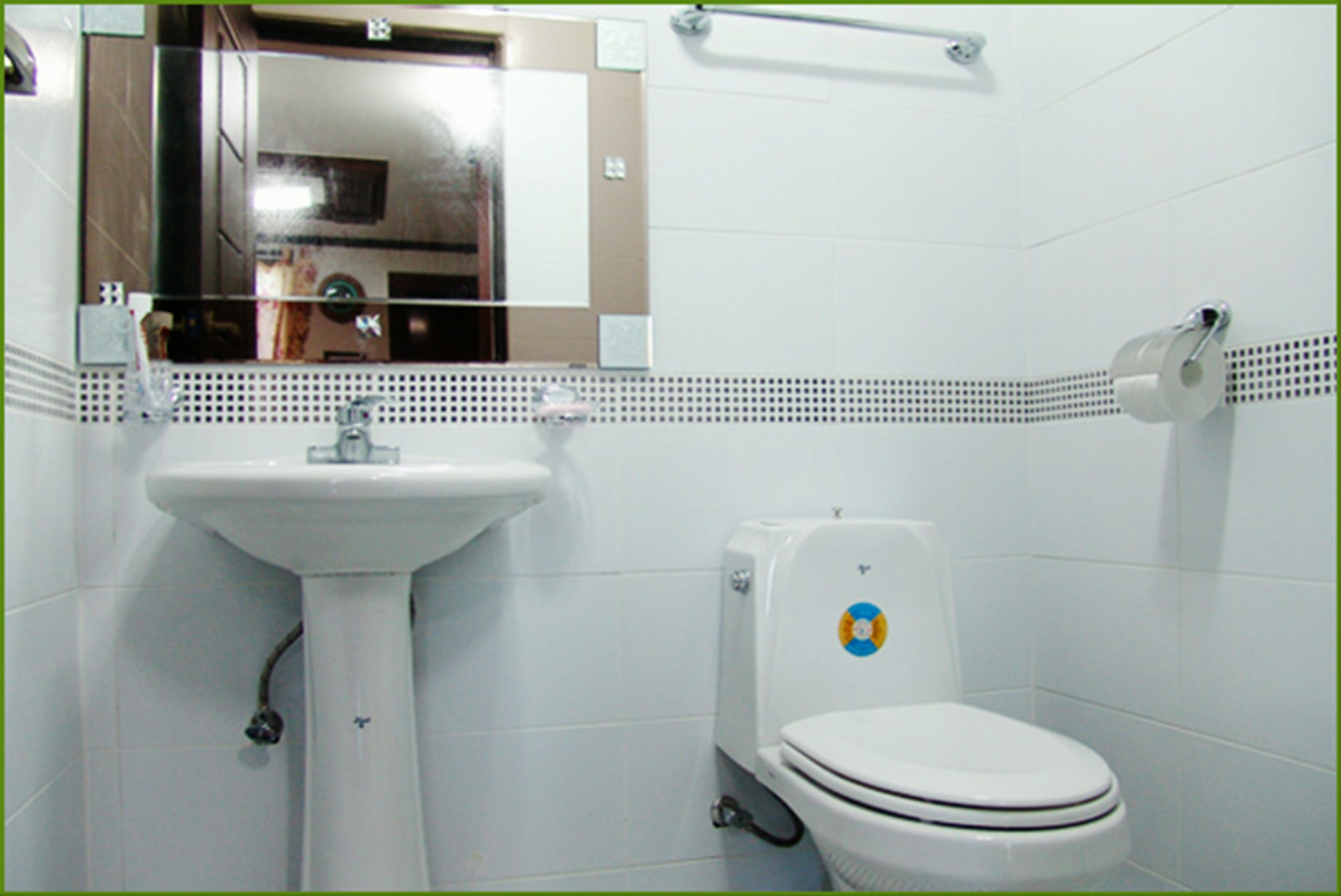 A bathroom with a white sink, toilet, and mirror.