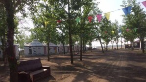 Ein Campingplatz mit Jurten, einer Bank und bunten Wimpeln.