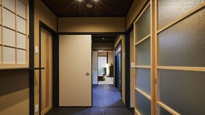 A corridor with sliding doors and a wooden floor, leading to a room with a view.