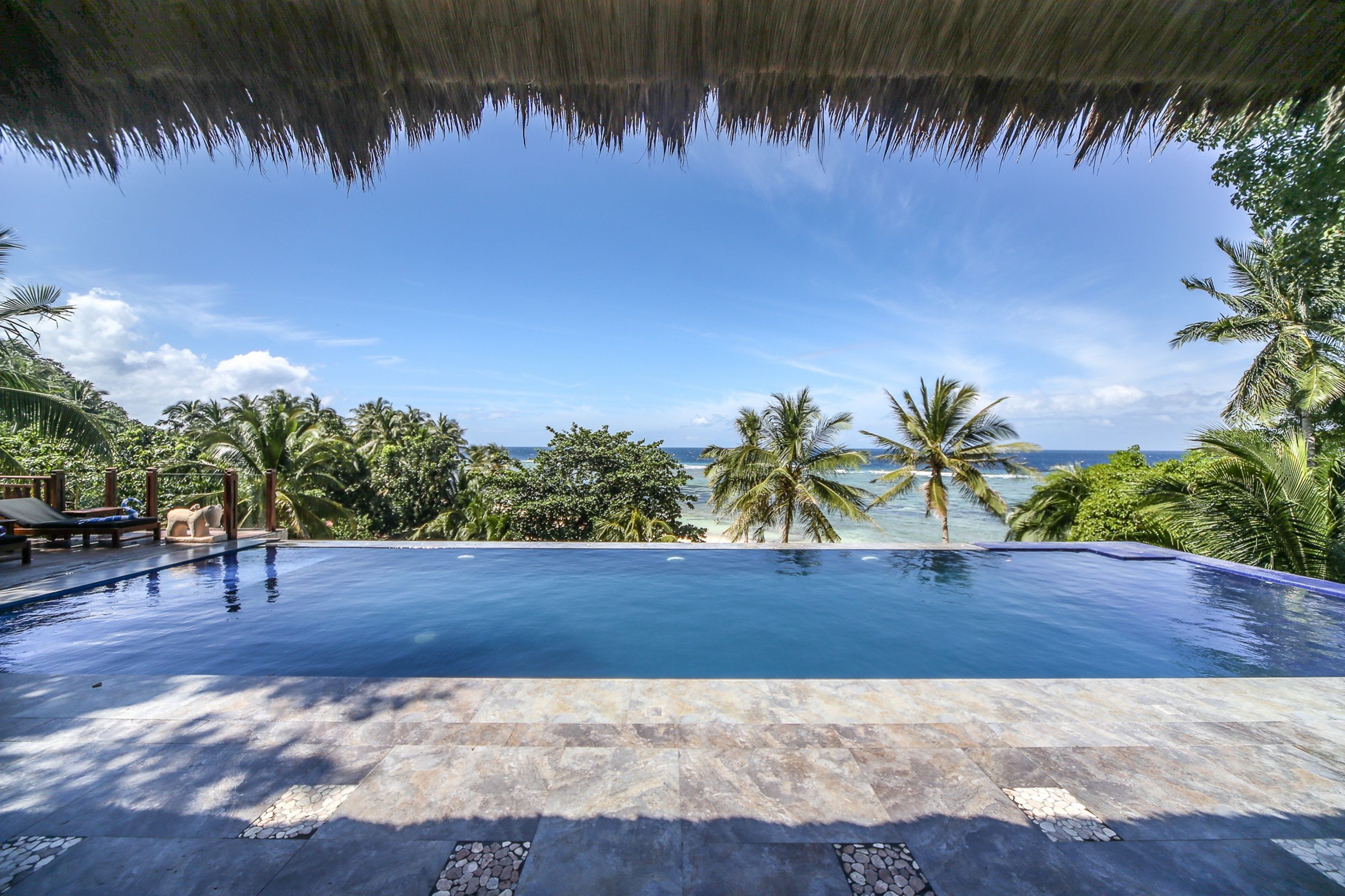 Outdoor pool, an infinity pool, pool umbrellas, pool loungers