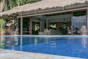 Una piscina al aire libre, una piscina con borde infinito, sombrillas