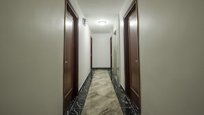 A narrow hallway with dark wooden doors and a marble floor. - Sao Bang Hotel (Hanoi)