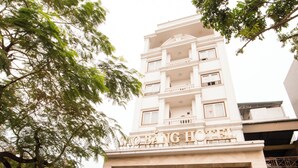 A hotel entrance with a sign reading "Sao Chung Hotel," a red car parked in front, and a staircase leading to the entrance. - Sao Bang Hotel (Hanoi)