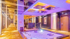 A hotel lobby with a central seating area, a reception desk, and a reception counter. - Delight Empire Hotel (Dongguan)