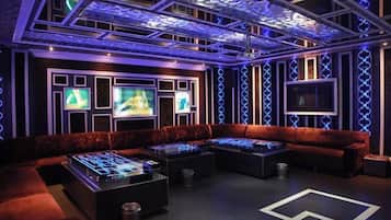 Ein stilvoller Lounge-Bereich mit einer Couch, einem Kicker und einem Flachbildfernseher.