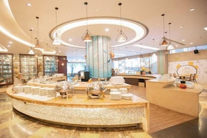 A modern hotel lobby with a central reception desk, a circular seating area, and pendant lighting. - Delight Empire Hotel (Dongguan)