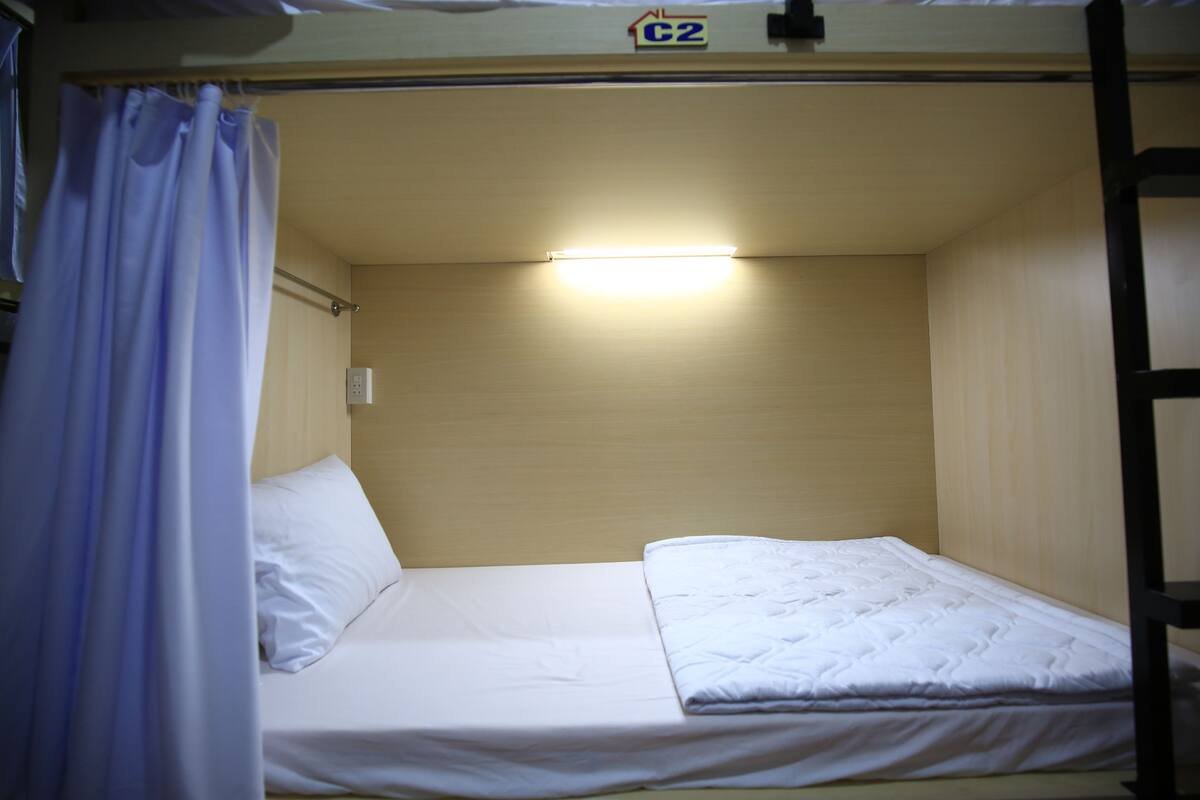 A bunk bed with a single mattress and a headboard.