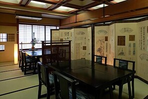 A traditional Japanese-style room with tatami mat flooring, a low table, and chairs. - Shouen (Izumo)