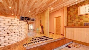 A wooden interior with a shoe rack, a wooden wall, and a wooden floor. - Shouen (Izumo)