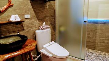 Une salle de bain avec un lavabo, des toilettes et une douche.