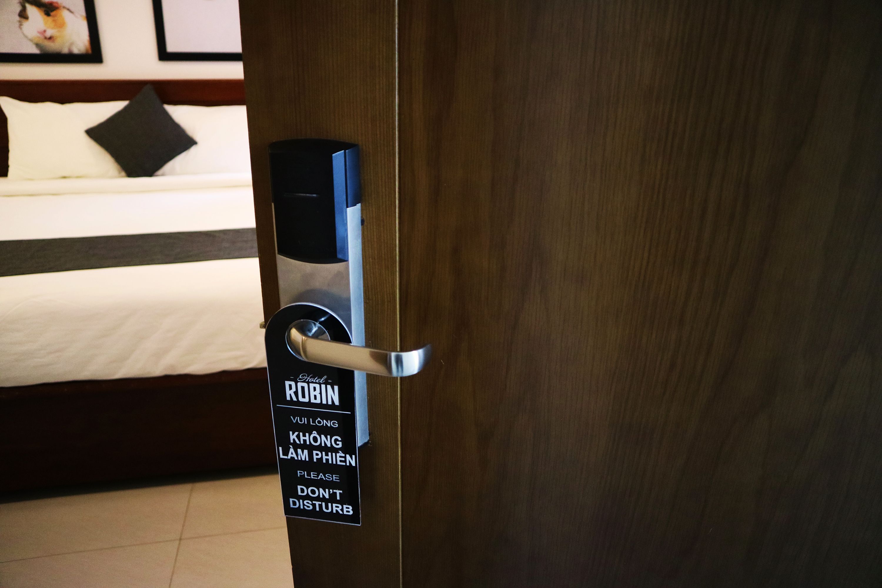 Puerta de una habitación de hotel con un letrero que dice RUBIN y un mensaje en vietnamita que indica no molestar.