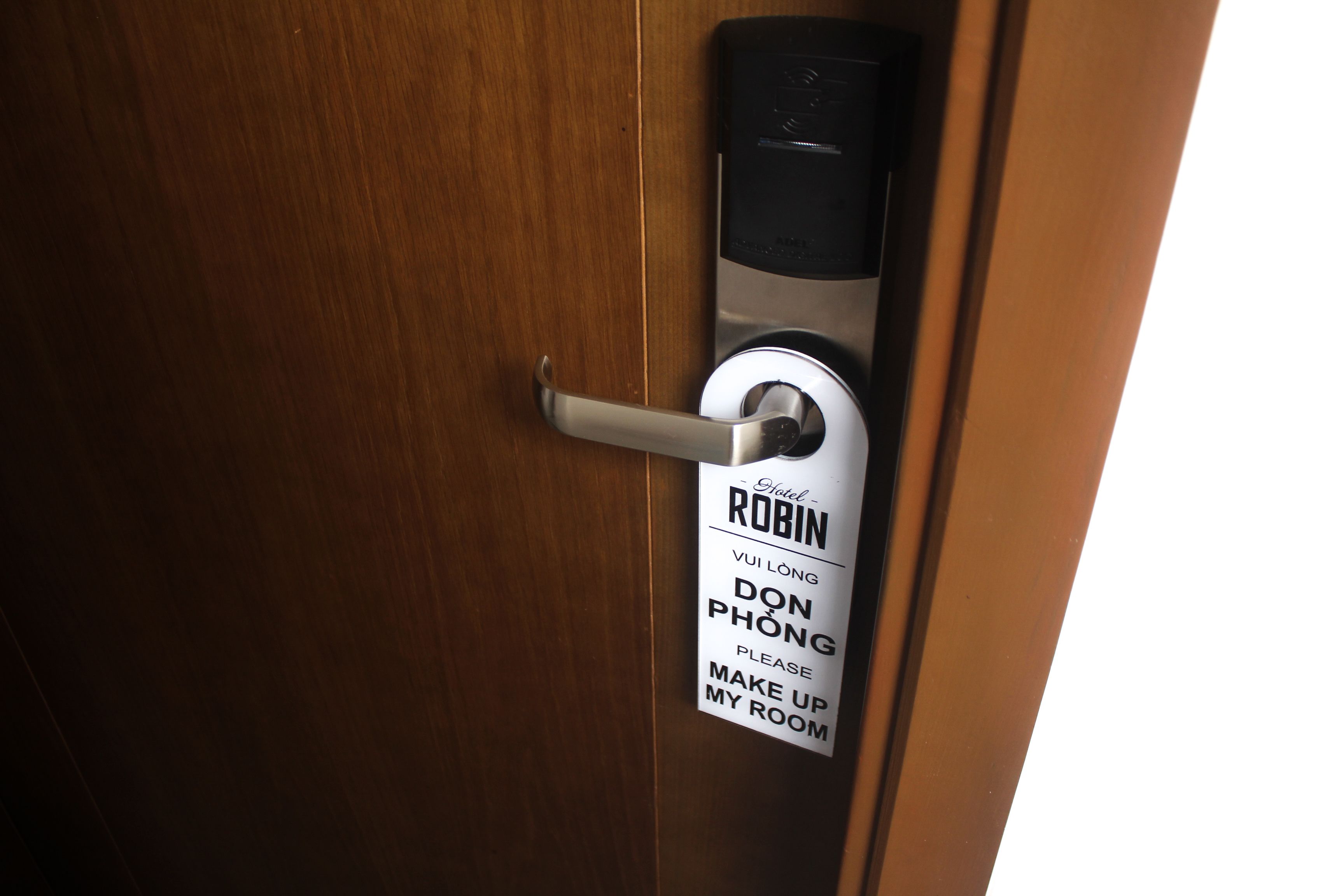 A hotel room door with a sign indicating the room number and a request for guests to make up their rooms.