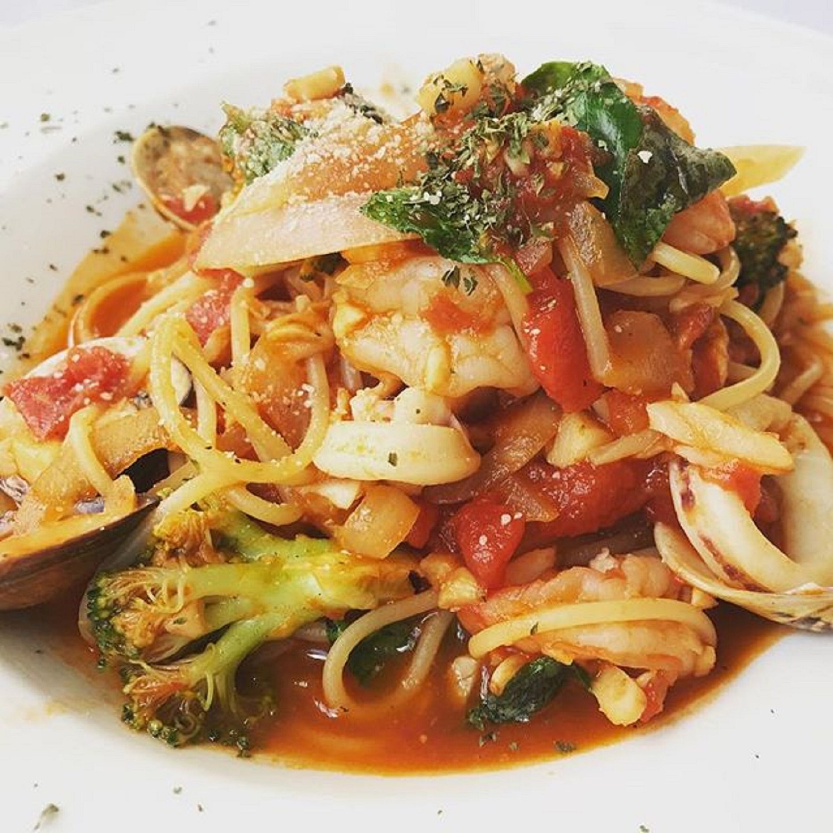 Un plato de pasta con verduras y queso.