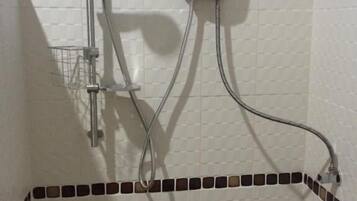 A shower with a handheld showerhead, a wall-mounted control unit, and a shower caddy.