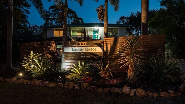 Ein modernes Haus mit einem Schild, auf dem "337 Torquay Terrace" steht, bei Nacht.