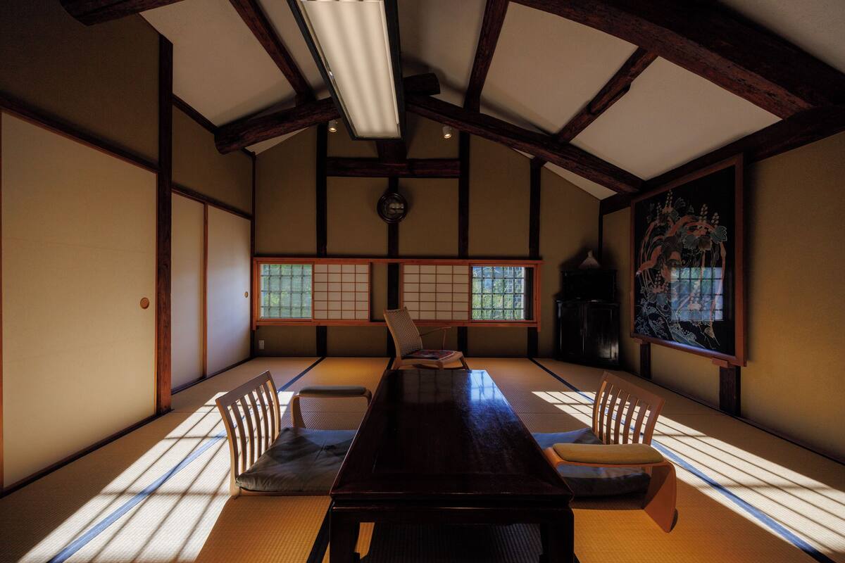 Ein traditioneller japanischer Raum mit Tatami-Böden, einem niedrigen Holztisch und Shoji-Schirmwänden.
