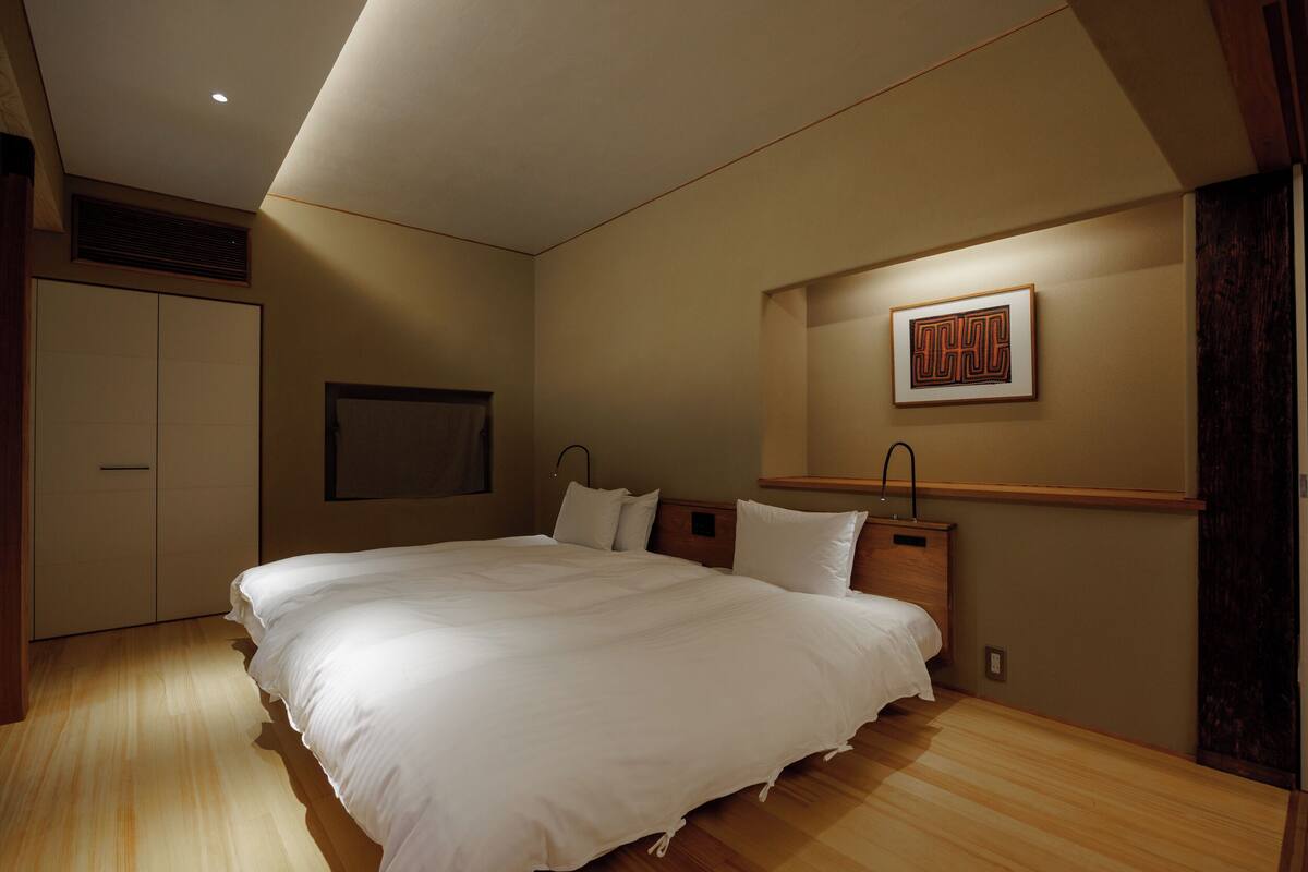 Ein Schlafzimmer mit einem großen Bett, einem Holzkopfende und einem gerahmten Bild an der Wand.
